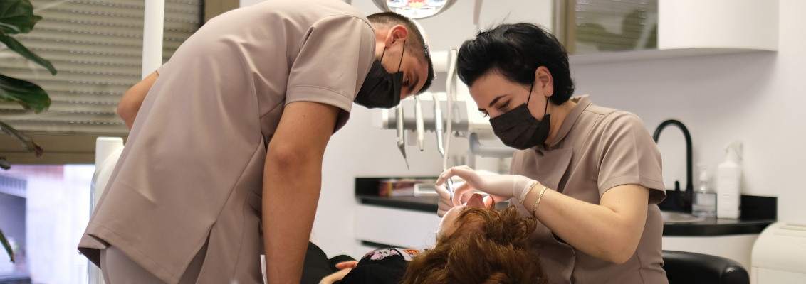 Dentisti che esaminano un paziente con attrezzatura moderna in clinica